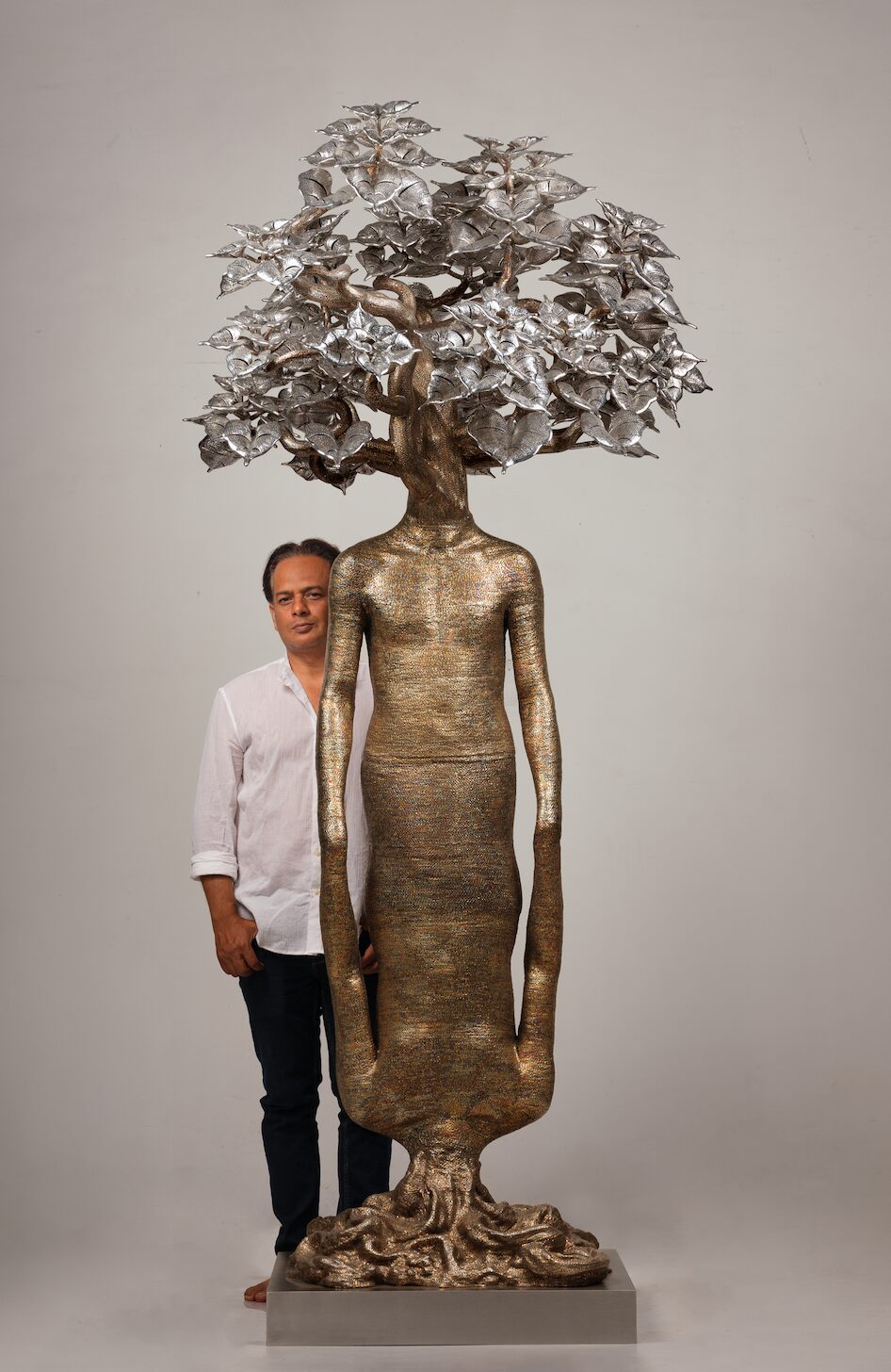 Dhananjay Singh standing beside his stainless steel wire sculpture Life Cycle